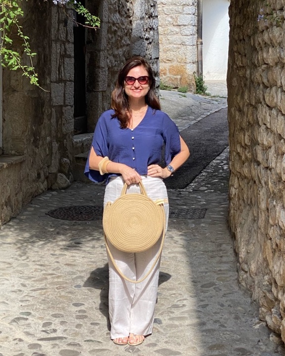 Foto de Mariana Pinheiro Pessoa de Andrade Aguiar, sorrindo, em uma rua de pedras.